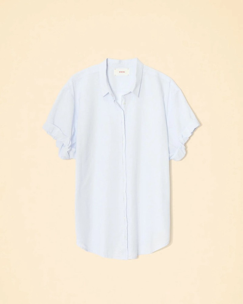 Pack af Xirena Channing shirt skylight kortærmet lyseblå skjorte på creme baggrund