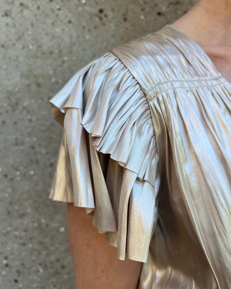Close up af Ulla Johnson Patrice Flutter Sleeve Midi Dress Opal kjole i perlemor plissé satin på model