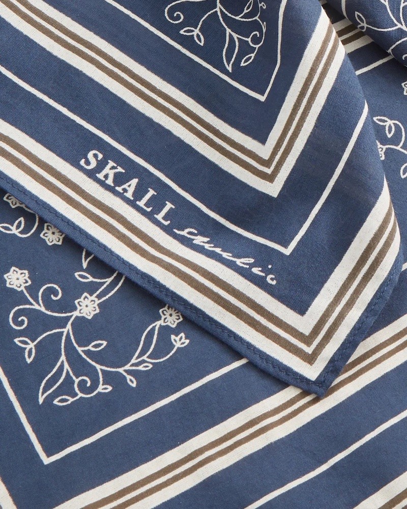 Close up af Skall Studio Classic Scarf Dark Navy med logo